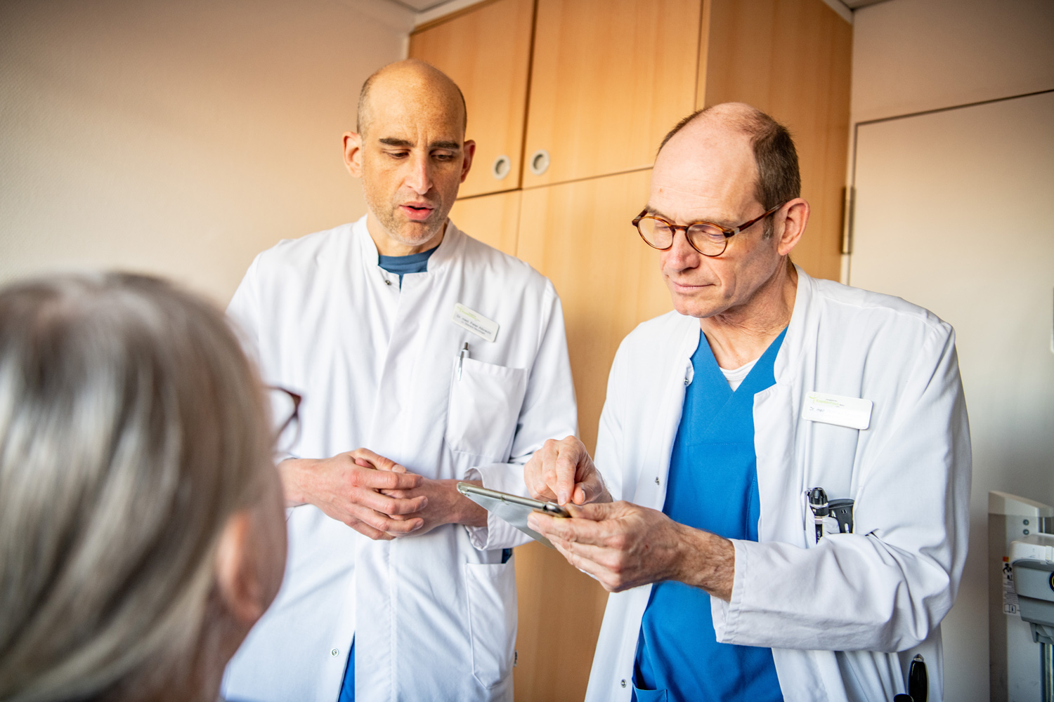 Zwei Ärzte bei der Visite einer Patientin der Neurologie
